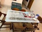 Glass top dinning table with wooden chairs